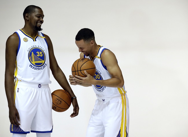Golden State Warriors' Kevin Durant, left, and Stephen Curry pose for photos during NBA basketball media day Monday, Sept. 26, 2016, in Oakland, Calif. (AP Photo/Marcio Jose Sanchez)