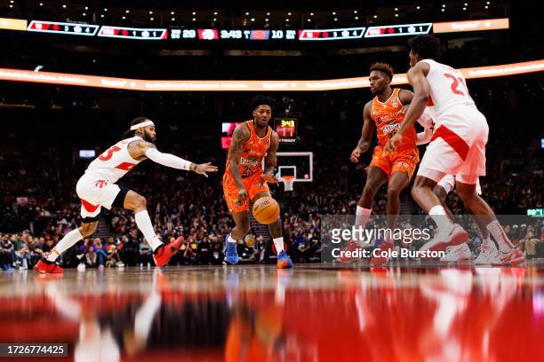 TORONTO, CANADA - OCTOBER 15: Elfrid Peyton #25 of the Cairns Taipans dribbles past Gary Trent Jr. (L) #33 of the Toronto Raptors during a preseason game at Scotiabank Arena on October 15, 2023 in Toronto, Canada. (Photo by Cole Burston/Getty Images)