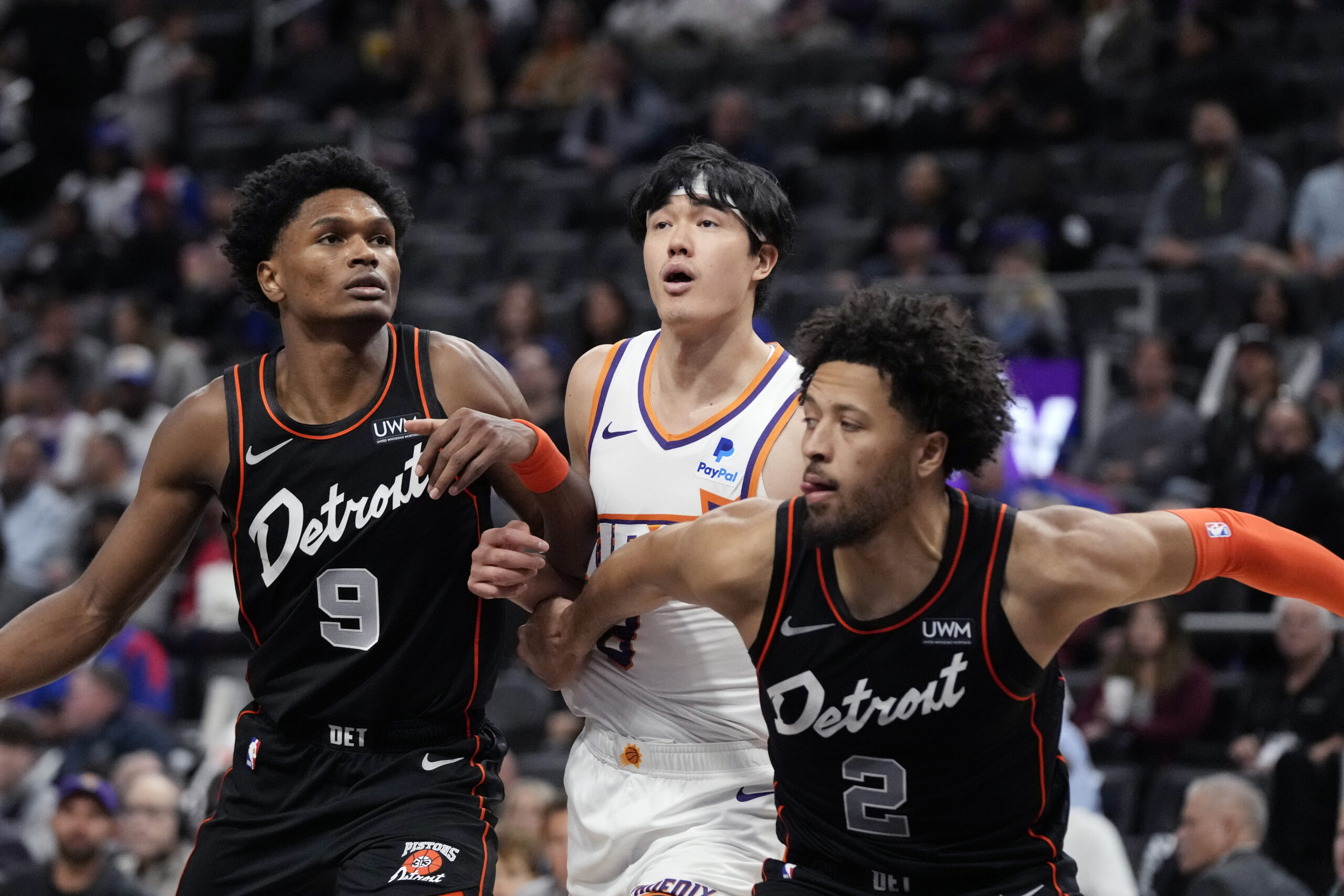 Phoenix Suns forward Yuta Watanabe, center, waits on the rebound with Detroit Pistons forward Ausar Thompson (9) and guard Cade Cunningham (2) during the first half of an NBA basketball game, Sunday, Nov. 5, 2023, in Detroit. (AP Photo/Carlos Osorio)